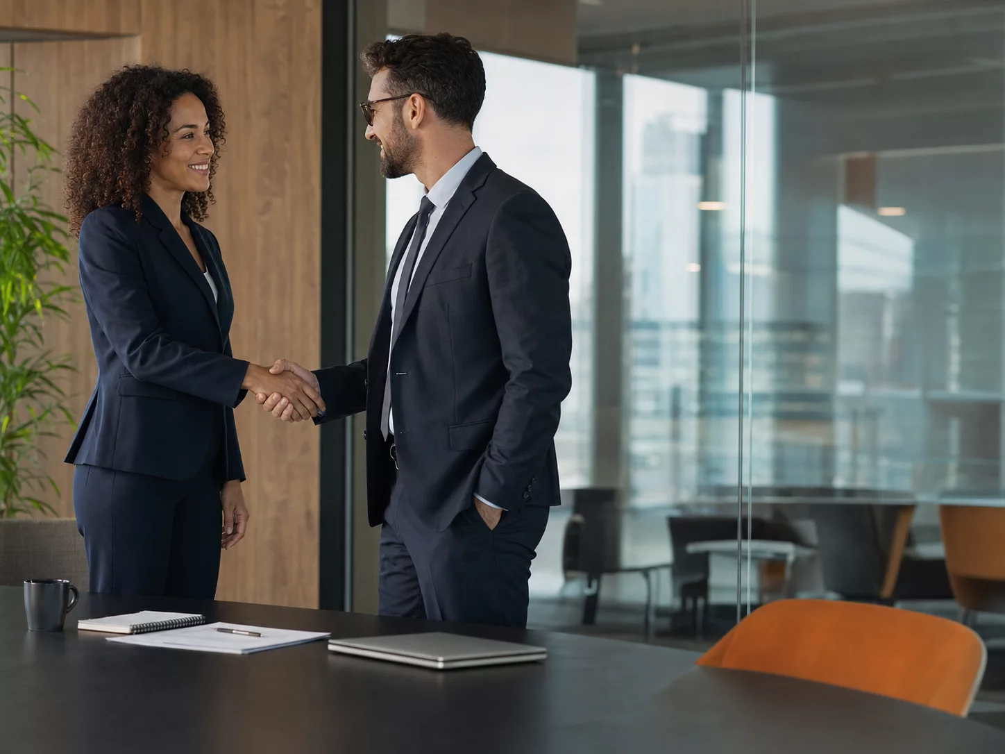 A confident recruiter shaking hands with a client after closing a deal